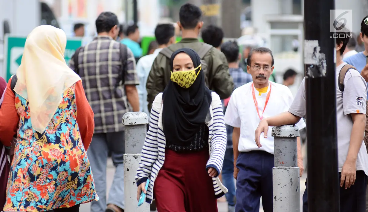Warga berjalan di pedestrian di kawasan Jalan Jenderal Sudirman, Jakarta, Jumat (14/7). Kepala Dinas LHK DKI Jakarta Isnawa Adji menjelaskan pihaknya terus berupaya melakukan pemantauan kualitas udara secara berkala. (Liputan6.com/Helmi Fithriansyah)