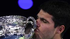 Carlos Alcaraz mencium piala usai berhasil menjuarai Australian Open 2026 setelah menaklukkan Novak Djokovic dalam laga sengit yang dilangsungkan di Melbourne Park pada (1/2/2026) sore WIB. (AFP/Martin Keep)