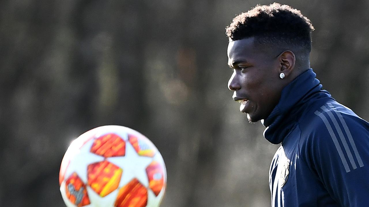 Pemain Manchester United, Paul Pogba, mengamati bola saat latihan jelang laga 16 besar Liga Champions. (AFP/Franck Fife)