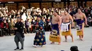 Juara Grand Sumo asal Mongolia, Kakuryu (kanan) tiba untuk melakukan upacara mengentakkan kaki menyambut tahun baru di Kuil Meiji Shrine, Tokyo, Selasa (9/1). Ritual penyambutan tahun baru itu melibatkan tiga juara pegulat sumo. (AP/Shizuo Kambayashi)