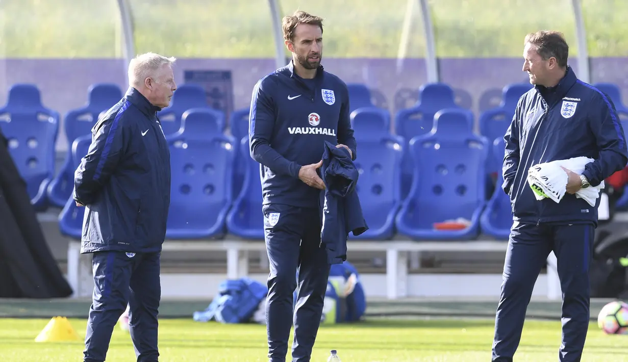 Pelatih sementara timnas Inggris, Gareth Southgate (tengah) saat berbincang dengan asistennya pada sesi latihan persiapan melawan Malta di St George's Park,  Burton-upon-Trent, (4/10/2016). AFP/Paul Ellis)