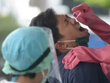 Warga menjalani "swab test" di GSI Lab (Genomik Solidaritas Indonesia Laboratorium), Cilandak, Jakarta, Rabu (7/10/2020). Pemerintah menetapkan harga batas tes usap alias tes swab melalui PCR untuk mendeteksi Covid-19 agar mendorong masyarakat melakukan tes secara mandiri. (merdeka.com/Imam Buhori)
