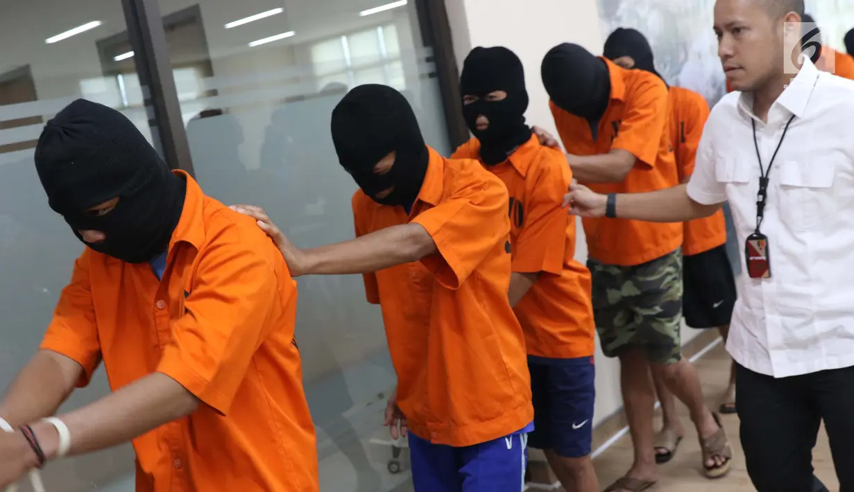 Tersangka kasus penyelundupan benih lobster digiring petugas di Gedung Dittipidter Bareskrim Mabes Polri, Jakarta, Selasa (13/8/2019). Bersama KKP, Polisi mengungkap penyelundupan 57.058 ekor benur jenis pasir dan jenis mutiara 203 ekor. (Liputan6.com/Helmi Fithriansyah)