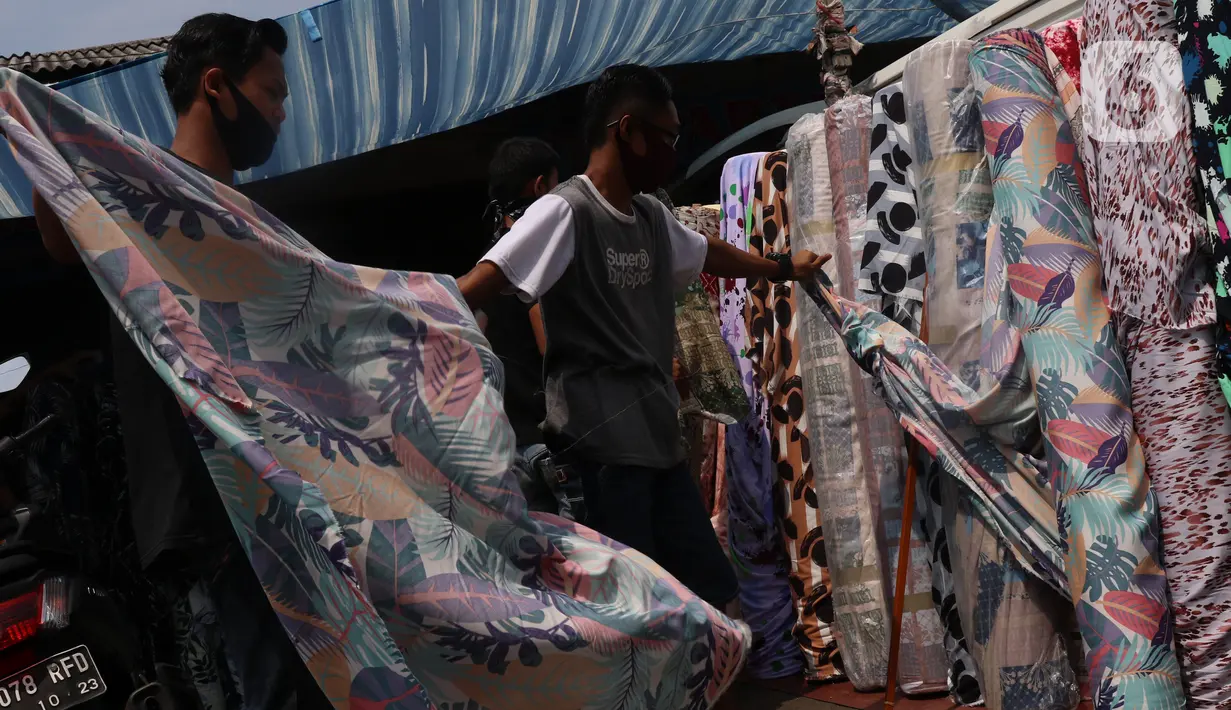 Aktivitas perdagangan tekstil di Pasar Cipadu, Tangerang, Senin (21/9/2020). Asosiasi Pertekstilan Indonesia (API) menyatakan industri Tekstil dan Produk Tekstil (TPT) sudah mulai beroperasi meski belum normal kembali akibat daya beli yang masih rendah di masa pandemi. (Liputan6.com/Angga Yuniar)