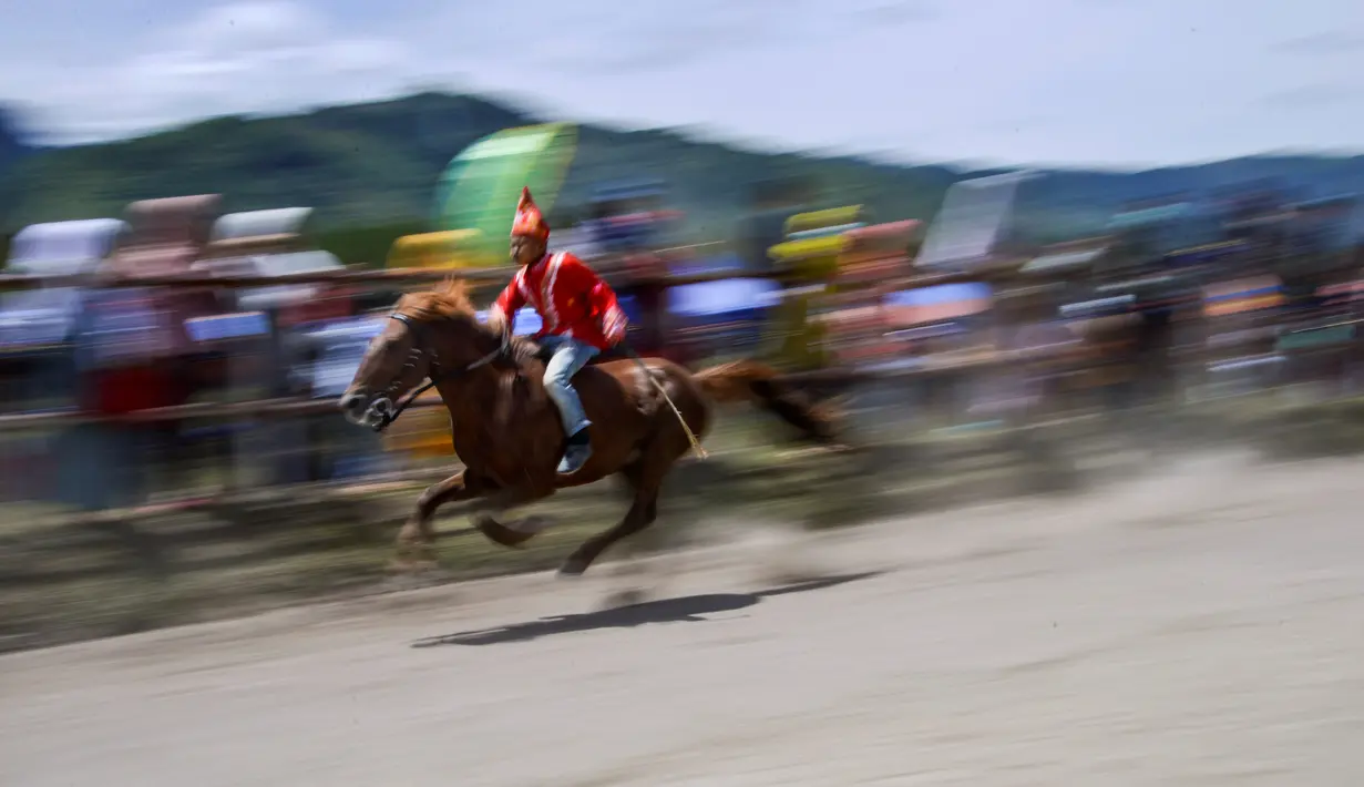 Seorang joki muda memacu kuda pada tradisi lomba pacuan kuda tradisional Gayo di Takengon, provinsi Aceh tengah, Sabtu (31/8/2019). Pacuan Kuda tradisional yang merupakan tradisi masyarakat Tanah Gayo tersebut diselenggarakan dua kali dalam setahun. (CHAIDEER MAHYUDDIN/AFP)