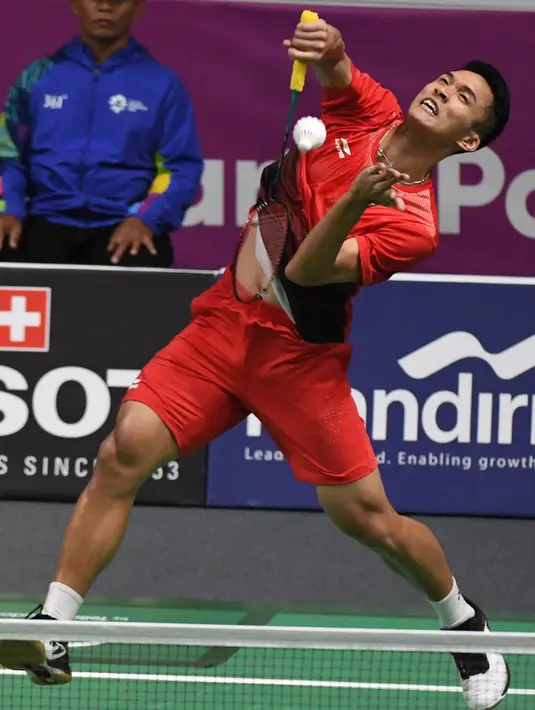 Pebulu tangkis Indonesia, Jonatan Christie mengembalikan kok saat bertanding melawan Kenta Nishimoto asal Jepang dalam semifinal tunggal putra Asian Games 2018 di Jakarta, Senin (27/8). Jonatan melaju ke final. (SONNY TUMBELAKA/AFP)