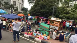 Suasana CFD yang berlangsung di kawasan Jalan Jenderal Sudirman-MH Thamrin, Jakarta, Minggu (11/2). Dishub mengeluarkan imbauan berupa spanduk karena para PKL memakan bahu jalan dan mengganggu aktivitas pengunjung CFD. (Liputan6.com/Immanuel Antonius)