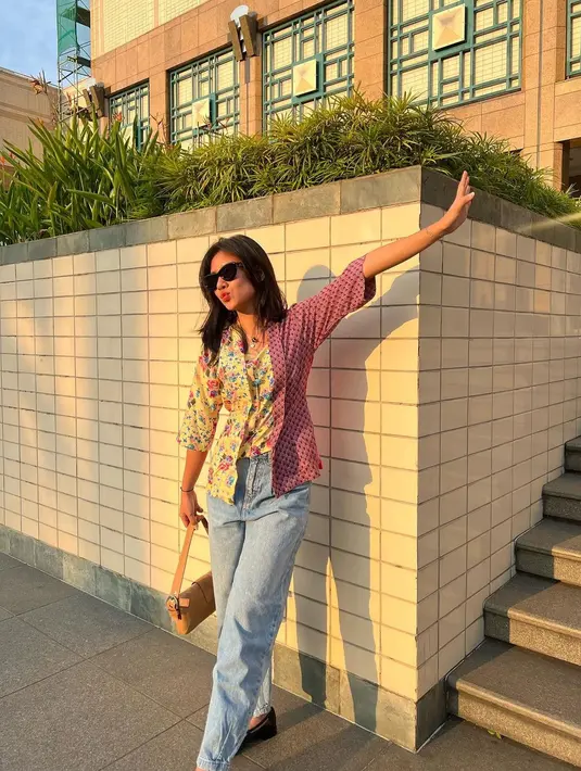 Tampil kasual dengan kebaya. Shenina Cinnamom memadukan kebaya motif floralnya dengan celana denim dan shoulder bag. [Instagram/shenacinnamon].