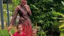 Nadine Chandrawinata tampil mengenakan kebaya coklat dipadukan bawahan kain batik merah. Kedua putrinya pun tampil mengenakan kebaya kutu baru. [@nadinelist]