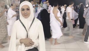 Yuni Shara berpose di depan Kabah mengenakan pakaian ihram. Untuk membawa perlengkapannya, ia mengenakan tas Gucci belt seharga sekitar Rp16 jutaan. (Dok. yunishara36)
