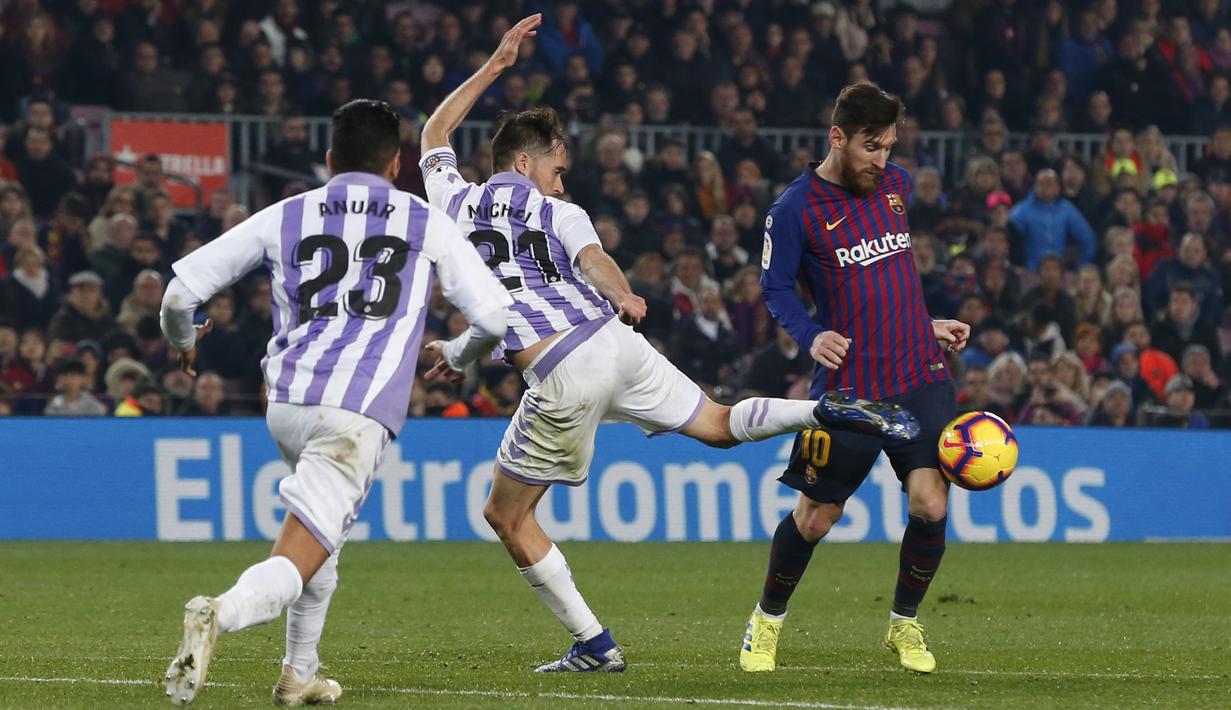 Gelandang Barcelona, Lionel Messi, berusaha melewati kepungan pemain Valladolid pada laga La Liga di Stadion Camp Nou, Barcelona, Sabtu (16/2). Barcelona menang 1-0 atas Valladolid. (AFP/Pau Barrena)