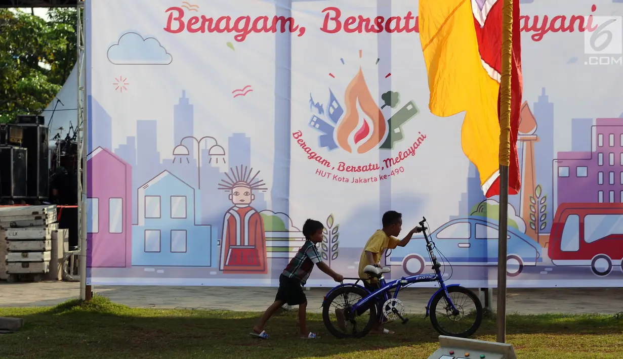 Dua orang anak bermain di depan baliho besar di Taman Kota Waduk Pluit, Jakarta, Jumat (19/5). Rencananya panggung ini akan digunakan sebagai tempat Konser Kebangkitan Nasional dan Pencanangan HUT Jakarta ke 490. (Liputan6.com/Helmi Fithriansyah)