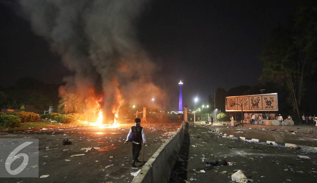 Sejumlah mobil dibakar pendemo saat terjadi bentrok dengan polisi di kawasan Monas, Jakarta, Jumat (4/11). Diduga bentrok terjadi saat massa HMI menyerang polisi dan polisi membalasnya dengan melempar gas air mata. (Liputan6.com/Immanuel Antonius)