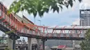 Pekerja menyelesaikan pembangunan jembatan penyeberangan orang (JPO) atau "Skywalk" di kawasan Kebayoran Lama, Jakarta, Sabtu (19/11/2022). Pemprov DKI Jakarta melalui Dinas Bina Marga DKI Jakarta membangun skywalk sepanjang 500 meter dengan desain dan cahaya artistik serta dilengkapi fasilitas lift juga eskalator. (Liputan6.com/Angga Yuniar)
