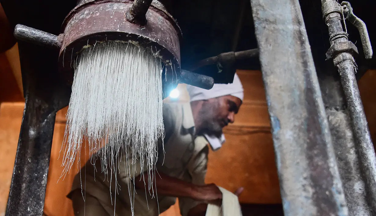 Pekerja menyiapkan bihun yang digunakan untuk membuat hidangan manis tradisional yang populer dikonsumsi selama bulan suci Ramadhan, di sebuah pabrik di Allahabad, India (5/4/2022). (AFP/Sanjay Kanojia)