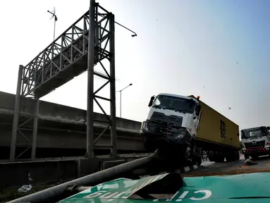 Kendaraan berat kontainer menabrak jalur pembatas pintu masuk tol akses Tanjung Priok di Jalan Raya Cilincing, Jakarta Utara, Sabtu (17/8/2019). Kejadian pada pukul 03.00 dini hari tadi terjadi akibat sopir mengantuk. Tidak ada korban jiwa dalam kejadian ini. (merdeka.com/Arie Basuki)
