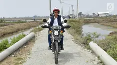 Presiden Joko Widodo mengendarai motor trail melintasi tambak udang di Muara Gembong, Bekasi (1/11). Jokowi menghadiri kegiatan Perhutanan Sosial untuk Pemerataan Ekonomi. (Liputan6.com/Biro Pers Kepresidenan/Agus Suparto)
