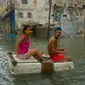 Sepasang warga menggunakan styrofoam untuk melewati jalanan yang terendam banjir di Hanava, Kuba, Minggu (10/9). Badai irma yang melanda pantai timur Perairan Kuba pada Jumat waktu setempat menyebabkan sebagian kota terendam banjir. (AP/Ramon Espinosa)