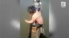 Seorang bocah laki-laki memancing dengan peraltan seadanya dan mendapatkan hasil yang mengejutkan.