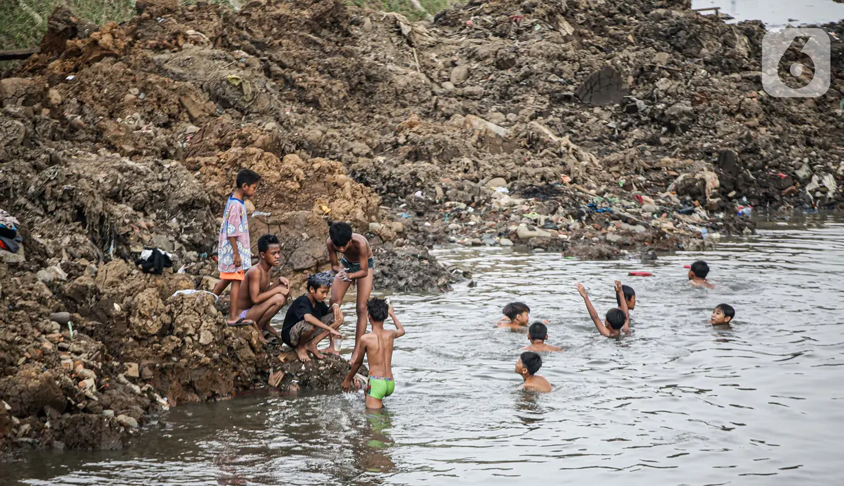 Anak-anak bermain di Sungai Ciliwung yang surut di kawasan Bukit Duri, Jakarta, Sabtu (8/8/2020). Penyusutan debit air Sungai Ciliwung tersebut karena memasuki masa kemarau 2020 yang menurut BMKG akan mencapai puncaknya pada Agustus. (Liputan6.com/Faizal Fanani)