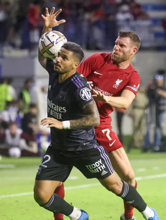 Gelandang Liverpool, James Milner (kanan) berebut bola dengan bek Lyon, Henrique selama pertandingan Dubai Super Cup 2022 di Al Maktoum Stadium, Uni Emirat Arab, Minggu (11/12/2022). Lyon menang atas Liverpool 3-1. (AFP/Karim Sahib)