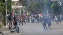 Pelajar melempari Gedung DPR dengan batu saat berunjuk rasa di Palmerah, Jakarta, Rabu (25/9/2019). Pihak kepolisian menembakan gas air mata untuk memukul mundur pelajar. (Liputan6.com/Angga Yuniar)