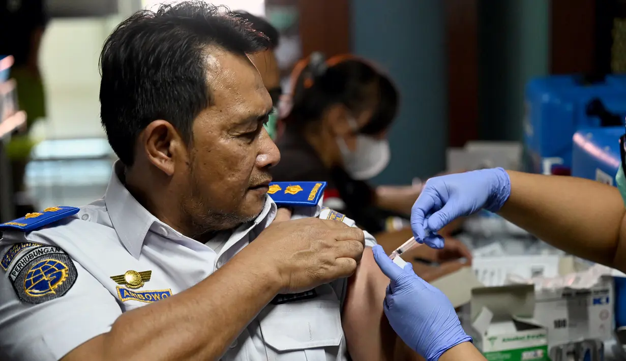 Seorang petugas bandara mendapatkan vaksinasi COVID-19 keempat atau booster kedua di kantor otoritas Bandara Ngurah Rai, dekat Denpasar, Bali, Senin (30/1/2023). Pemerintah Provinsi (Pemprov) Bali melakukan program vaksinasi booster kedua usai dibukanya penerbangan langsung (direct flight) dari China pada Minggu (22/1) lalu. (SONNY TUMBELAKA / AFP)