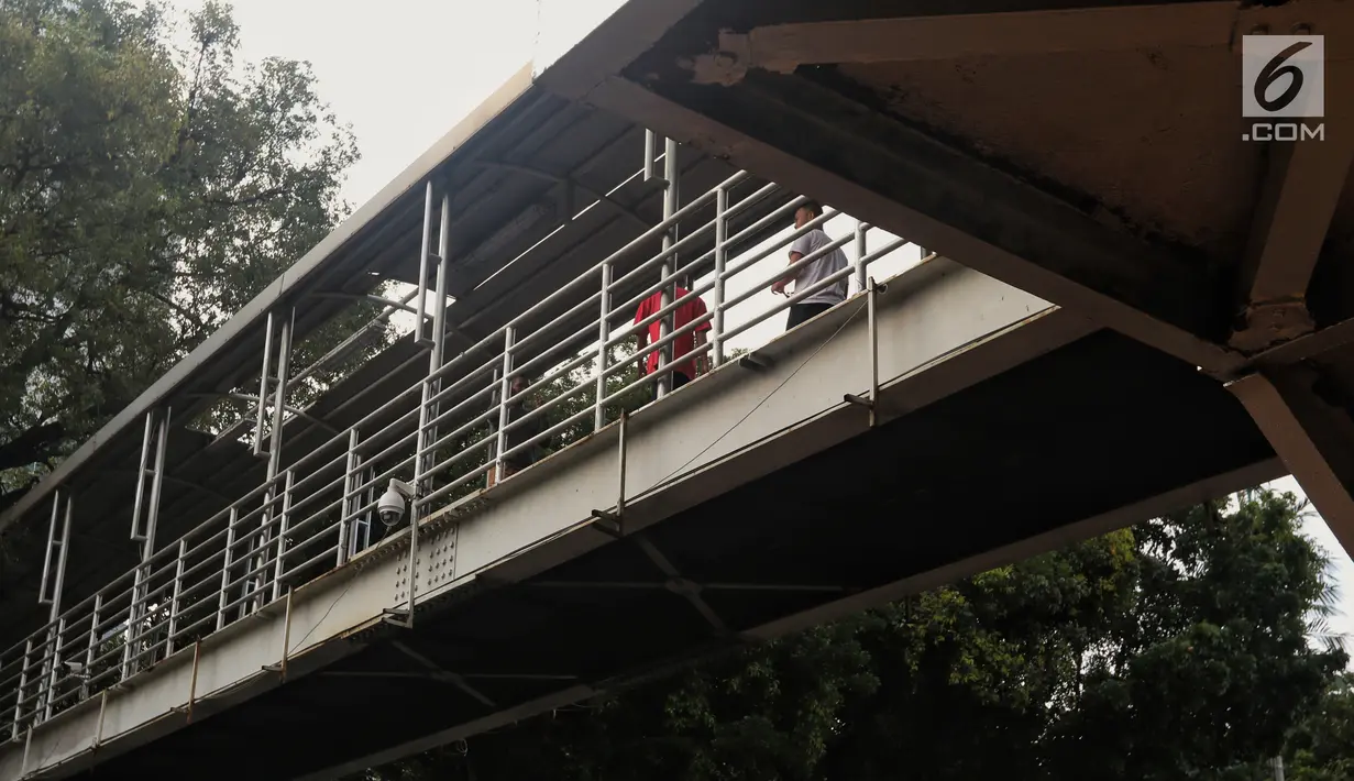 Atap yang rusak di JPO Medan Merdeka Barat, Jakarta, Jumat (19/1). Kondisi JPO yang penuh dengan genangan air dan atap yang rusak ini mengurangi kenyamanan bagi para pejalan kaki yang menggunakannya. (Liputan6.com/Johan Tallo)
