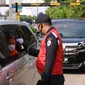 Petugas mengecek suhu tubuh penumpang di Rest Area KM 13,5 Palm Square Tol Jakarta-Tangerang, Jumat (29/5/2020). Penerepan parkir berjarak dan pengecekan suhu tubuh di area tersebut diberlakukan untuk menekan penyebaran Covid-19. (Liputan6.com/Angga Yuniar)