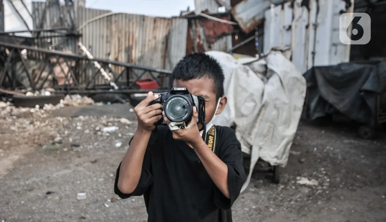 Seorang anak belajar memotret saat Kelas Jurnalis Cilik di Cilincing, Jakarta, Minggu (6/6/2021). Kelas Jurnalis Cilik menjadi wadah bagi anak-anak pesisir yang mengedukasi tentang jurnalistik seperti penulisan dan fotografi. (merdeka.com/Iqbal S Nugroho)