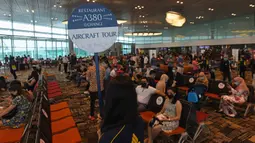 Pengunjung menunggu untuk menikmati makan siang perdana di Restaurant A380 @Changi di pesawat Airbus A380, di Bandara Internasional Changi, 24 Oktober 2020. Restoran A380 @Changi menyajikan pengalaman makan eksklusif dalam pesawat Singapore Airlines A380 pada 24-25 Oktober. (ROSLAN RAHMAN/AFP)