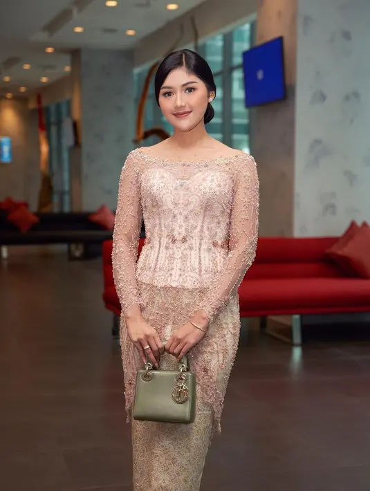Dalam agenda ‘Kebaya Indonesia menuju UNESCO’, Erina mengenakan kebaya sabrina bernuansa champagne dan kain songket nuansa emas.