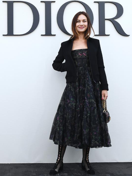 Aktris Olga Kurylenko berpose sebelum acara peragaan busana koleksi Christian Dior di Paris, Prancis, 24 September 2018. Olga Kurylenko mengaku merasa demam dan kelelahan sebelum akhirnya dinyatakan positif terjangkit virus corona COVID-19. (Photo by Anne-Christine POUJOULAT/AFP)