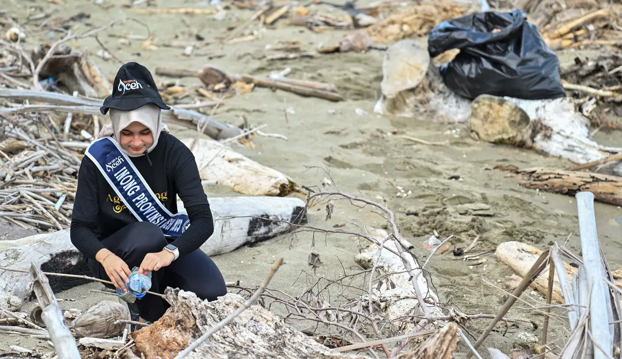 Duta wisata Inong (perempuan) turun langsung memungut sampah. (CHAIDEER MAHYUDDIN/AFP)