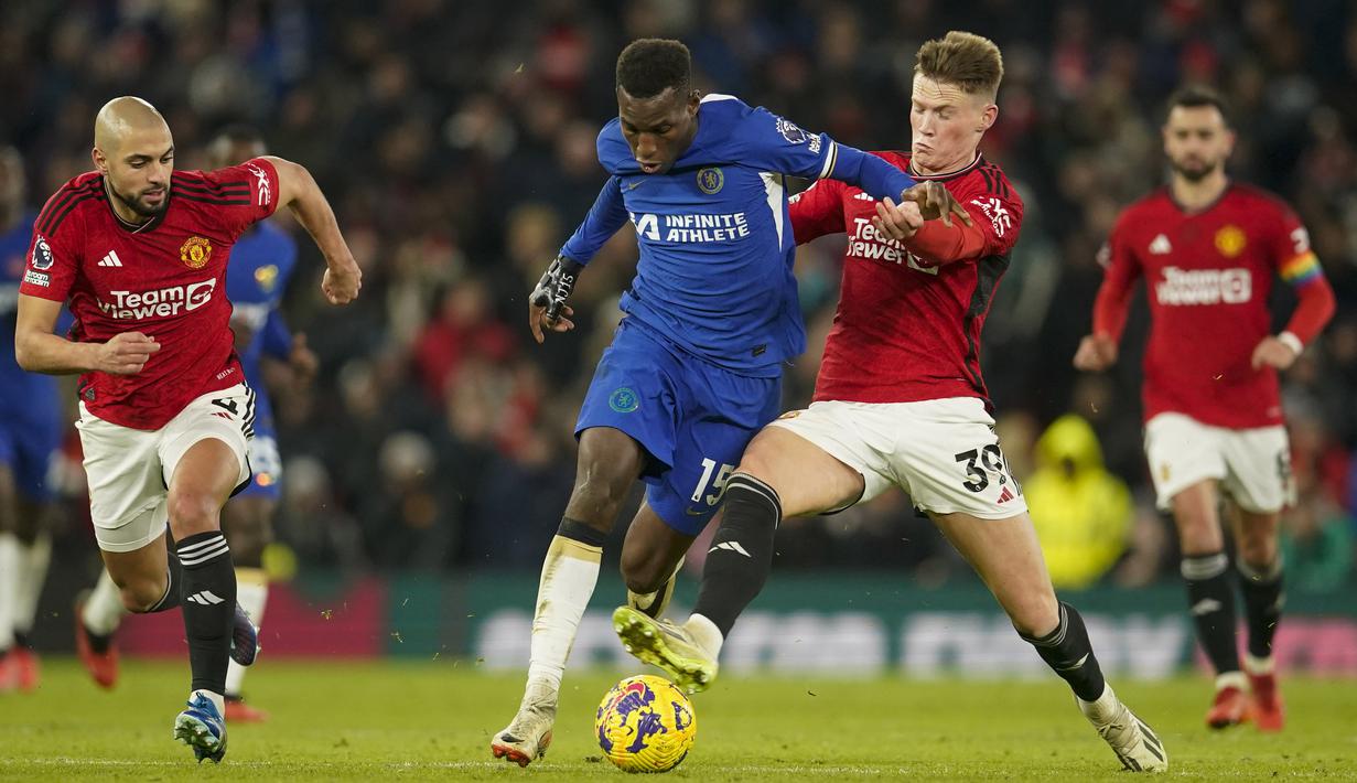 Pemain Manchester United, Scott McTominay (dua kanan), berhasil merebut bola dari pemain Chelsea, Nicolas Jackson (tengah), dalam pertandingan pekan ke-15 Liga Inggris 2023/2024 yang berlangsung di Old Trafford, Kamis (7/12/2023) dini hari WIB. (AP Photo/Dave Thompson)