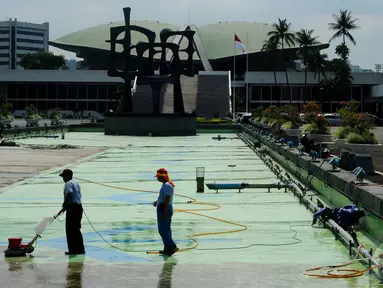 Petugas membersihkan kolam yang ada di halaman Gedung Parlemen, Senayan, Jakarta, Rabu (10/12/2014). (Liputan6.com/Andrian M Tunay)