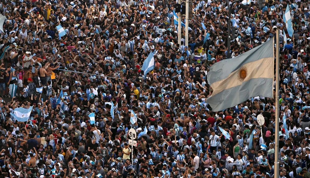 Para penggemar Argentina merayakan kemenangan atas Kroasia pada pertandingan semifinal Piala Dunia Qatar 2022 di Obelisk di Buenos Aires, Rabu (14/12/2022). Keberhasilan mengalahkan Kroasia membuat Argentina lolos ke final Piala Dunia untuk keenam kalinya. (AFP/Luis Robayo)