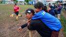 Seorang anak digendong bapaknya tampak asik menyaksikan pertandingan antara Ad-Sya FC melawan Dejan FC di Lapangan Latus Jaya, Kedaung, Pamulang, Minggu (12/3/2023). (Bola.com/M Iqbal Ichsan)