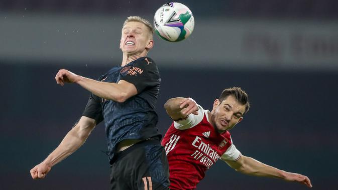 Gelandang Manchester City, Oleksandr Zinchenko dan bek Arsenal, Cedric Soares berebut bola pada laga perempatfinal Piala Liga Inggris di Emirates Stadium, Rabu (23/12/2020) dini hari WIB. Man City melenggang ke semifinal Piala Liga Inggris lewat kemenangan 4-1 atas Arsenal. (AP Photo/Frank Augstein)