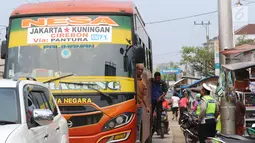 Petugas polisi mengatur lalu lintas di pasar Tumpah Bangkir Indramayu, Jawa Barat, Jumat (30/6). Sebaliknya kearah Indramayu Kota mengalami kemacetan arus lalu lintas sepanjang 3 Km. (Liputan6.com/Helm Afandi)