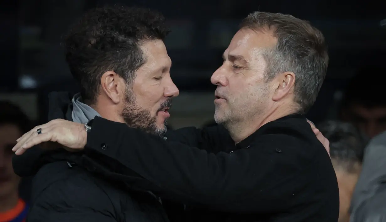 Pelatih Barcelona, Hansi Flick (kanan) bersalaman dengan pelatih Atletico Madrid, Diego Simeone dalam laga leg 1 semifinal Copa del Rey 2024/2025 di Estadi Olimpic Lluis Companys, Barcelona, Rabu (26/02/2025) dini hari WIB. (AFP/Lluis Gene)