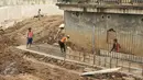 Pekerja menyelesaikan proyek normalisasi sungai Ciliwung di kawasan Bukit Duri, Jakarta, Rabu (8/2). Normalisasi sungai Ciliwung terus dikebut, pihak kontraktor terus menyelesaikan sheetpile dan dinding parapet.(Liputan6.com/Yoppy Renato)
