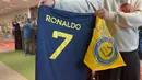 Kepastian bergabungnya Cristiano Ronaldo pada 31 Desember 2022 bersama klub papan atas Arab Saudi, Al Nassr langsung berpengaruh signifikan dari sisi bisnis. Para fans Al Aalami, julukan bagi Al Nassr, berbondong-bondong mengunjungi toko resmi pernak-pernik klub Al Nassr di Riyadh untuk berburu jersey bernomor punggung 7 bertuliskan "Ronaldo". (AFP/Fayez Nureldine)
