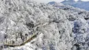 Para wisatawan menikmati pemandangan salju di objek wisata Longtoushan di Distrik Nanzheng di Hanzhong, Provinsi Shaanxi, China barat laut yang terlihat dari foto udara pada 20 Desember 2020. Warna putih mendominasi pemandangan di musim dingin. (Xinhua/Tao Ming)