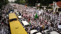 Ribuan Umat muslim  membentangkan spanduk dan mengibarkan bendera saat melakukan aksi menuju Balai Kota Jakarta, Jumat (14/10). Mereka mendesak Gubernur DKI Jakarta, Basuki Tjahaja Purnama mundur. (Liputan6.com/Hemi Fithriansyah)