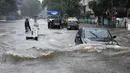 Sejumlah kendaraan melintasi banjir setelah hujan lebat di Mumbai, India (9/7). Mumbai dan daerah pinggiran lainnya telah mengalami hujan lebat semalaman yang mengakibatkan banjir. (AFP Photo/Indranil Mukherjee)