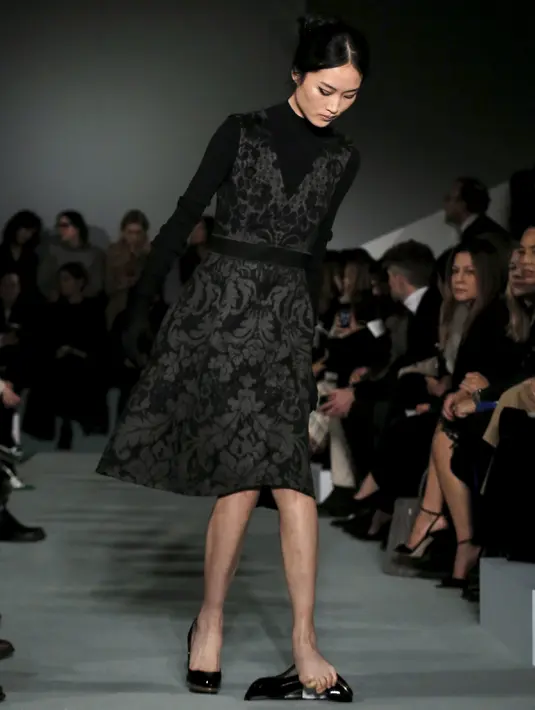 Seorang model memperhatikan sepatunya yang terlepas ketika memperagakan koleksi Oscar de la Renta Fall/Winter 2016 pada pagelaran New York Fashion Week di New York, Selasa (16/2/2016). (REUTERS/Brendan McDermid)