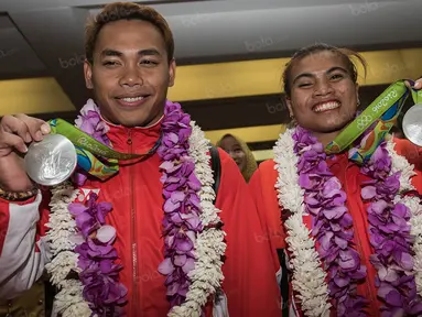 Lifter Indonesia peraih medali perak Olimpiade 2016 Rio de Janeiro, Eko Yuli dan Sri Wahyuni (kanan), tiba di Bandara Soekarno-Hatta, Tanggerang, Banten, Minggu (14/8/2016). (Bola.com/Vitalis Yogi Trisna)