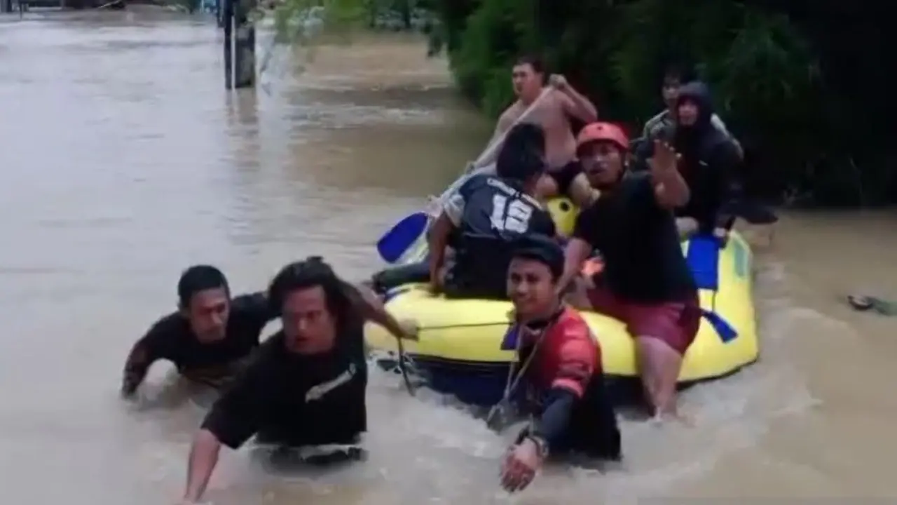 Warga Desa Bojongsari, Kecamatan Kedungwaringin, Kabupaten Bekasi mengevakuasi korban banjir yang meninggal dunia usai tenggelam.