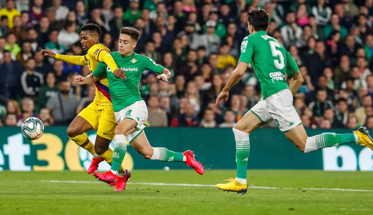 Bek kiri Barcelona, Junior Firpo, berebut bola dengan pemain Real Betis, Alex Moreno pada lanjutan Liga Spanyol pekan ke-23 di Benito Villamarin, Minggu (9/2/2020). Diwarnai dua kartu merah, Barcelona mememangkan duel menegangkan lawan Real Betis 3-2. (AP/Miguel Morenatti)